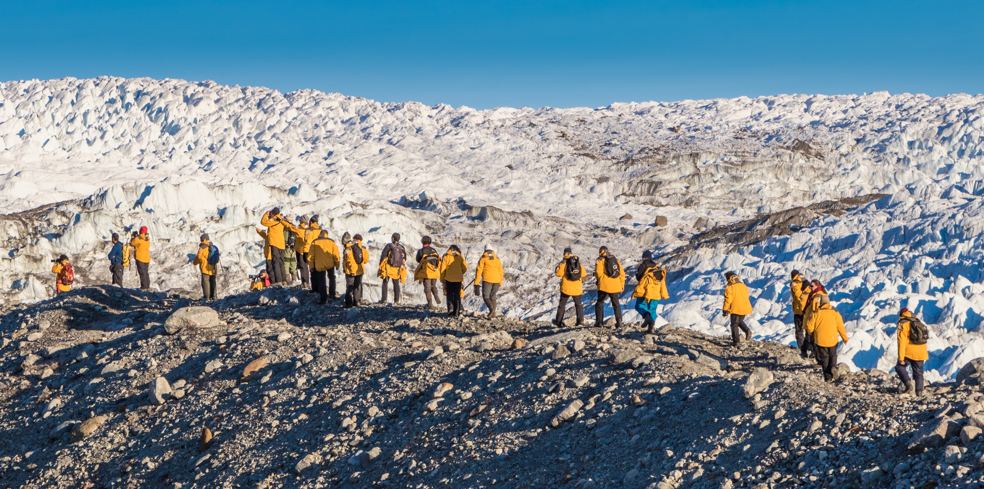 Quark passengers take a guided hike over rugged Greenland terrain on an expedition shore landing.