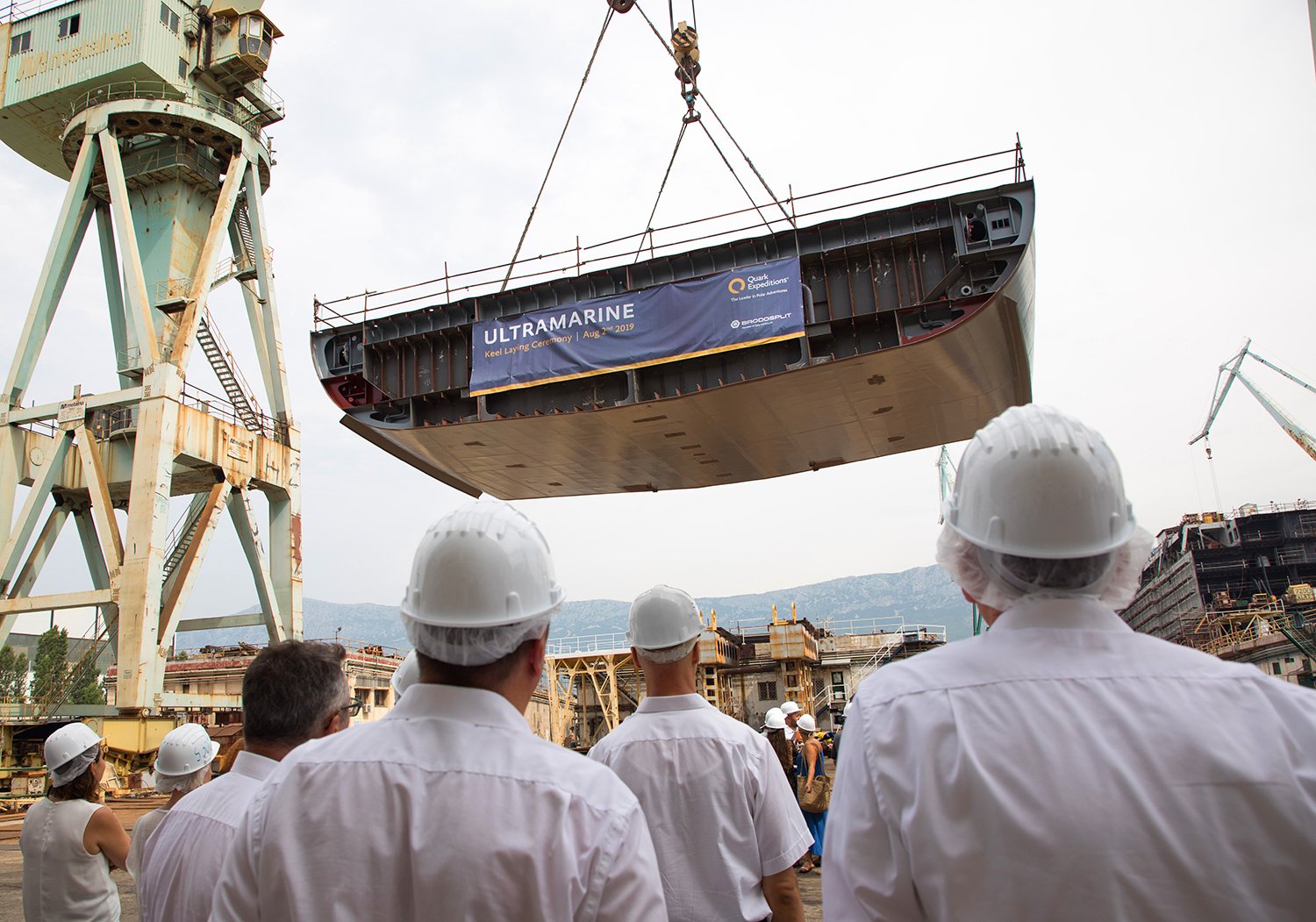Invited guests watch as the keel of Ultramarine is lowered into place for the ceremony
